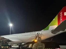 Agente da Polícia Federal acompanha, na pista do Aeroporto Internacional de Florianópolis, o embarque de cidadão finlandês em voo internacional durante operação de expulsão do país.