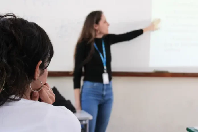 Professora conduz aula em sala de aula, representando o trabalho dos professores ACTs em Santa Catarina.