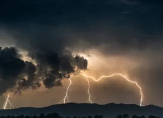 Imagem ilustrativa da frente fria: nuvens escuras e carregadas com raios sobre a cidade, representando a instabilidade e os temporais previstos para Santa Catarina.