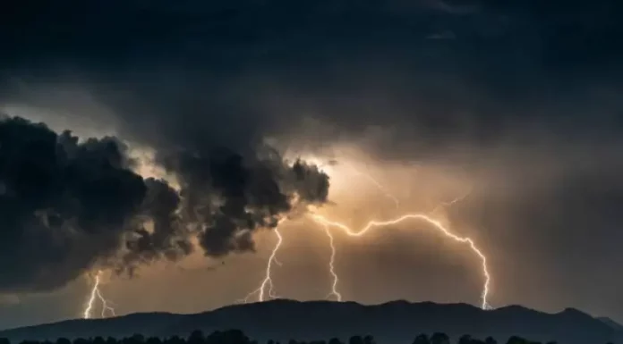 Imagem ilustrativa da frente fria: nuvens escuras e carregadas com raios sobre a cidade, representando a instabilidade e os temporais previstos para Santa Catarina.