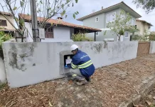 Técnico da Águas de Palhoça realiza leitura e inspeção em hidrômetro residencial, representando as atividades operacionais da concessionária.