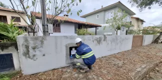 Técnico da Águas de Palhoça realiza leitura e inspeção em hidrômetro residencial, representando as atividades operacionais da concessionária.