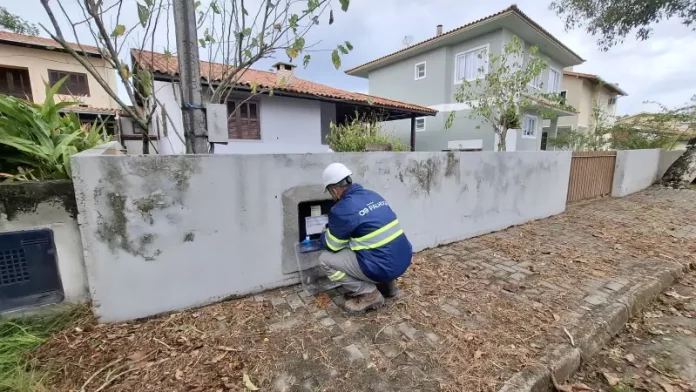 Técnico da Águas de Palhoça realiza leitura e inspeção em hidrômetro residencial, representando as atividades operacionais da concessionária.