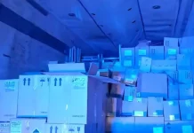 Imagem do interior do baú de um caminhão, mostrando caixas contendo vinhos finos, perfumes e cosméticos, apreendidos pela PRF em operação contra contrabando.