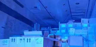 Imagem do interior do baú de um caminhão, mostrando caixas contendo vinhos finos, perfumes e cosméticos, apreendidos pela PRF em operação contra contrabando.
