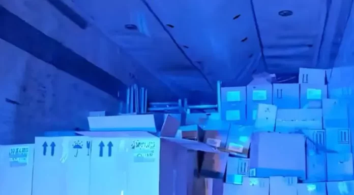 Imagem do interior do baú de um caminhão, mostrando caixas contendo vinhos finos, perfumes e cosméticos, apreendidos pela PRF em operação contra contrabando.