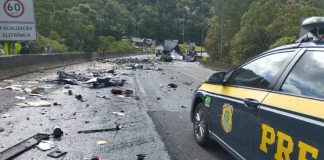 Imagem mostra trecho da BR-376 com destroços espalhados após grave acidente entre van, caminhão e carreta; viatura da Polícia Rodoviária Federal realiza atendimento no local.