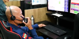 Bombeiro do CBMSC trabalha no computador enquanto fala no rádio para ilustrar o uso de tecnologias que apoiam o atendimento às ocorrências.