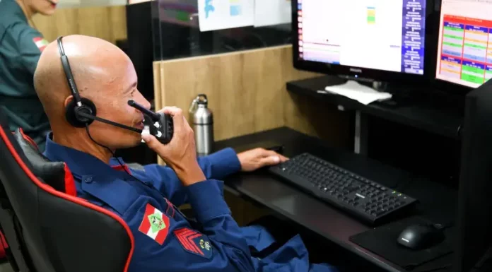 CBMSC apresenta nova ferramenta para monitorar atendimento em tempo real Bombeiro do CBMSC trabalha no computador enquanto fala no rádio para ilustrar o uso de tecnologias que apoiam o atendimento às ocorrências.