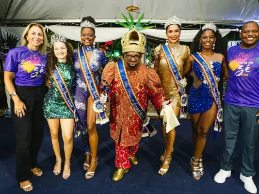 São José abre inscrições para o concurso da Rainha e Corte do Carnaval 2026 Secretário de Cultura de São José posa ao lado da Corte do Carnaval 2025 durante apresentação oficial do concurso.