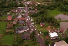 Defesa Civil confirma ocorrência de três tornados no Oeste de Santa Catarina Vista aérea mostra parte de Dionísio Cerqueira após a passagem de tornados, com casas destelhadas, destroços espalhados e equipes atuando nas ruas para avaliar os danos e prestar atendimento à população. A imagem ilustra a dimensão dos estragos causados pelo fenômeno climático.