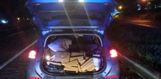 Menor de idade é apreendido com 300 quilos de maconha e carro roubado após perseguição em Joinville Porta-malas aberto exibindo tabletes de maconha apreendidos, registrados para documentar a ação policial.