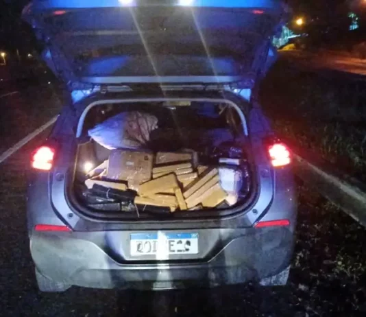 Porta-malas aberto exibindo tabletes de maconha apreendidos, registrados para documentar a ação policial.