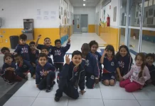 Crianças da educação infantil sentadas no pátio da escola, representando as vagas disponíveis para matrículas em 2026.