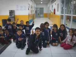 Crianças da educação infantil sentadas no pátio da escola, representando as vagas disponíveis para matrículas em 2026.