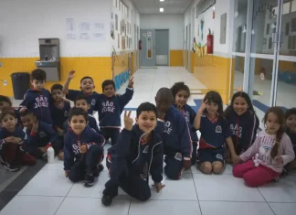 Crianças da educação infantil sentadas no pátio da escola, representando as vagas disponíveis para matrículas em 2026.