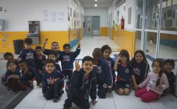 Crianças da educação infantil sentadas no pátio da escola, representando as vagas disponíveis para matrículas em 2026.