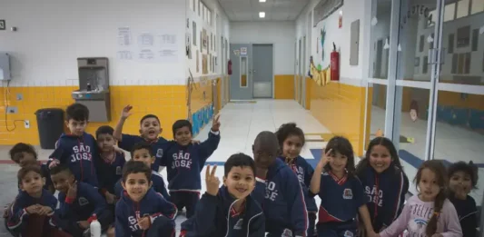 Crianças da educação infantil sentadas no pátio da escola, representando as vagas disponíveis para matrículas em 2026.