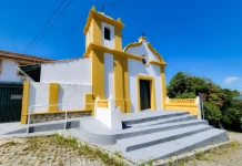 Cantinhos de São José: A igreja que deu origem à procissão do Senhor do Bonfim Foto da fachada da Capela do Senhor do Bonfim em São José, destacando sua arquitetura luso-brasileira e a entrada principal da igreja.