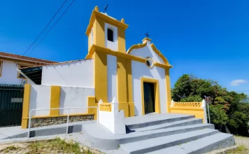 Foto da fachada da Capela do Senhor do Bonfim em São José, destacando sua arquitetura luso-brasileira e a entrada principal da igreja.
