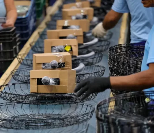 Santa Catarina mantém ritmo de crescimento acima da média nacional em 2025 Operários trabalhando em uma linha de montagem de uma indústria catarinense, ilustrando o avanço da produção e o crescimento econômico acima da média nacional.