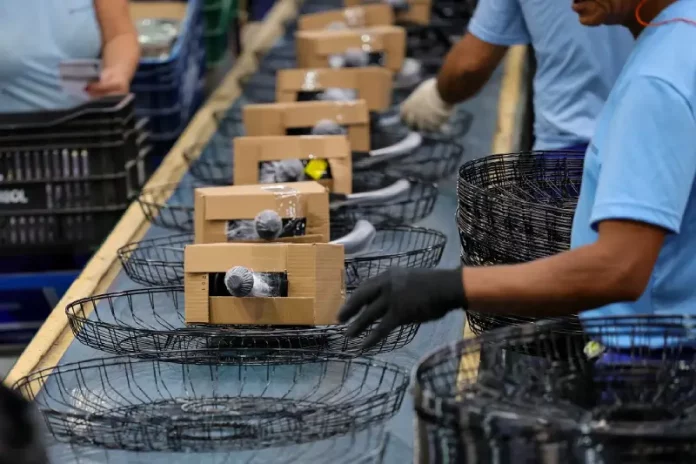 Industria-Ventisol-7101 Operários trabalhando em uma linha de montagem de uma indústria catarinense, ilustrando o avanço da produção e o crescimento econômico acima da média nacional.