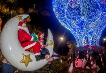 São José lança o Natal Iluminado e estreia a Vila Mágica do Natal Luzes da Esperança A imagem mostra uma cena natalina usada para divulgar o Natal Iluminado de São José. Um Papai Noel decorativo está sentado em uma lua gigante ao lado de uma criança, enquanto ao fundo aparece uma grande estrutura iluminada em azul em formato de balão e famílias aproveitam o espaço. A foto reforça o clima festivo e a proposta de oferecer atrações para as famílias durante o evento.