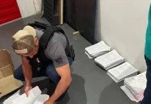 Agentes da Polícia Civil revisam documentos relacionados a investigação de fraudes em processos de transferência de veículos na Ciretran de São José.