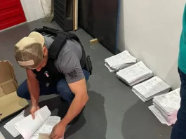 Agentes da Polícia Civil revisam documentos relacionados a investigação de fraudes em processos de transferência de veículos na Ciretran de São José.