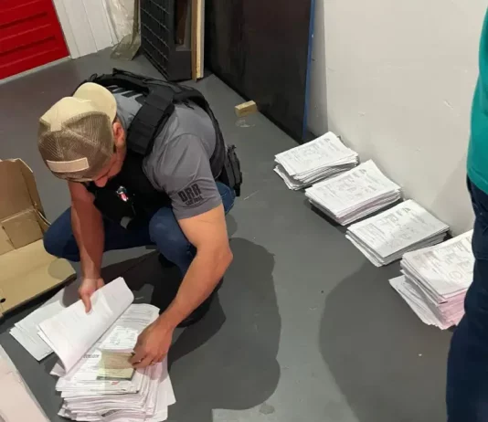 Agentes da Polícia Civil revisam documentos relacionados a investigação de fraudes em processos de transferência de veículos na Ciretran de São José.