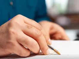 Prefeitura de Biguaçu abre processos seletivos para diversas áreas Pessoa preenche formulário de inscrição, representando a abertura de processos seletivos pela Prefeitura de Biguaçu.