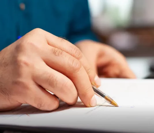 Pessoa preenche formulário de inscrição, representando a abertura de processos seletivos pela Prefeitura de Biguaçu.