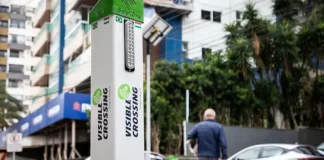 Foto do equipamento SafeXOne instalado em uma faixa de pedestres, mostrando a tecnologia que aumenta a segurança e alerta os motoristas.