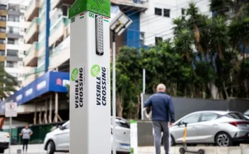 Foto do equipamento SafeXOne instalado em uma faixa de pedestres, mostrando a tecnologia que aumenta a segurança e alerta os motoristas.