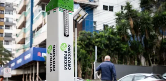 Foto do equipamento SafeXOne instalado em uma faixa de pedestres, mostrando a tecnologia que aumenta a segurança e alerta os motoristas.