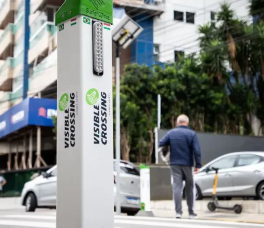 Foto do equipamento SafeXOne instalado em uma faixa de pedestres, mostrando a tecnologia que aumenta a segurança e alerta os motoristas.