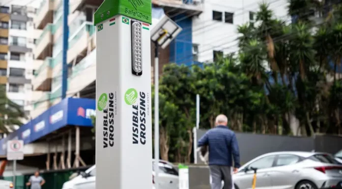 Foto do equipamento SafeXOne instalado em uma faixa de pedestres, mostrando a tecnologia que aumenta a segurança e alerta os motoristas.