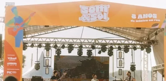 A imagem mostra o palco principal do festival Som & Sol durante uma apresentação musical, ilustrando a proposta do evento de promover música ao vivo e integração do público em um espaço cultural ao ar livre.