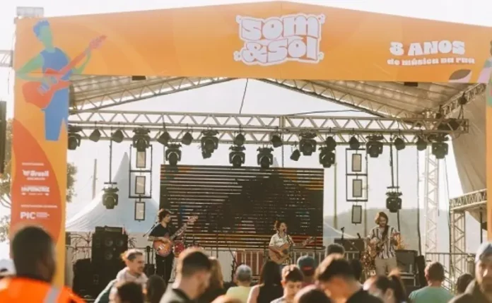 Som & Sol A imagem mostra o palco principal do festival Som & Sol durante uma apresentação musical, ilustrando a proposta do evento de promover música ao vivo e integração do público em um espaço cultural ao ar livre.