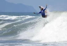 Atleta em ação sobre a onda, ilustrando a final do campeonato brasileiro de surfe.