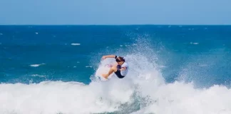 Atleta executa manobra em onda durante a abertura do Campeonato Brasileiro de Surfe de Ondas Grandes, destacando a força e a técnica do esporte.
