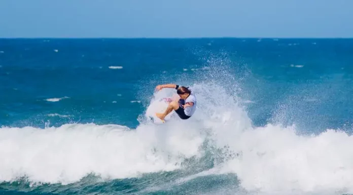 Atleta executa manobra em onda durante a abertura do Campeonato Brasileiro de Surfe de Ondas Grandes, destacando a força e a técnica do esporte.