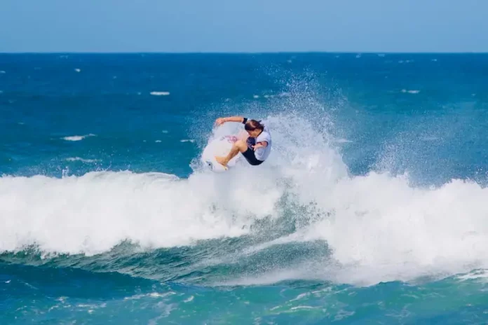 Atleta executa manobra em onda durante a abertura do Campeonato Brasileiro de Surfe de Ondas Grandes, destacando a força e a técnica do esporte.