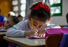 Menina participando de atividades em sala de aula da educação infantil, representando o período em que os estudantes poderão realizar matrículas e transferências escolares.