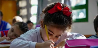 Menina participando de atividades em sala de aula da educação infantil, representando o período em que os estudantes poderão realizar matrículas e transferências escolares.