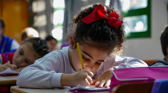 Menina participando de atividades em sala de aula da educação infantil, representando o período em que os estudantes poderão realizar matrículas e transferências escolares.