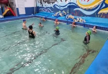 São José oferece aulas de natação para crianças com foco na prevenção de afogamentos Crianças participando de aulas de natação com instrutores, ilustrando o projeto voltado à prevenção de afogamentos em São José.