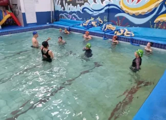 São José oferece aulas de natação para crianças com foco na prevenção de afogamentos Crianças participando de aulas de natação com instrutores, ilustrando o projeto voltado à prevenção de afogamentos em São José.
