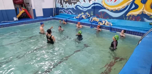 São José oferece aulas de natação para crianças com foco na prevenção de afogamentos Crianças participando de aulas de natação com instrutores, ilustrando o projeto voltado à prevenção de afogamentos em São José.