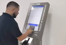 Homem utiliza um terminal de autoatendimento da Celesc para emitir segunda via ou regularizar serviços, mostrando a finalidade de facilitar o acesso rápido aos procedimentos da companhia.